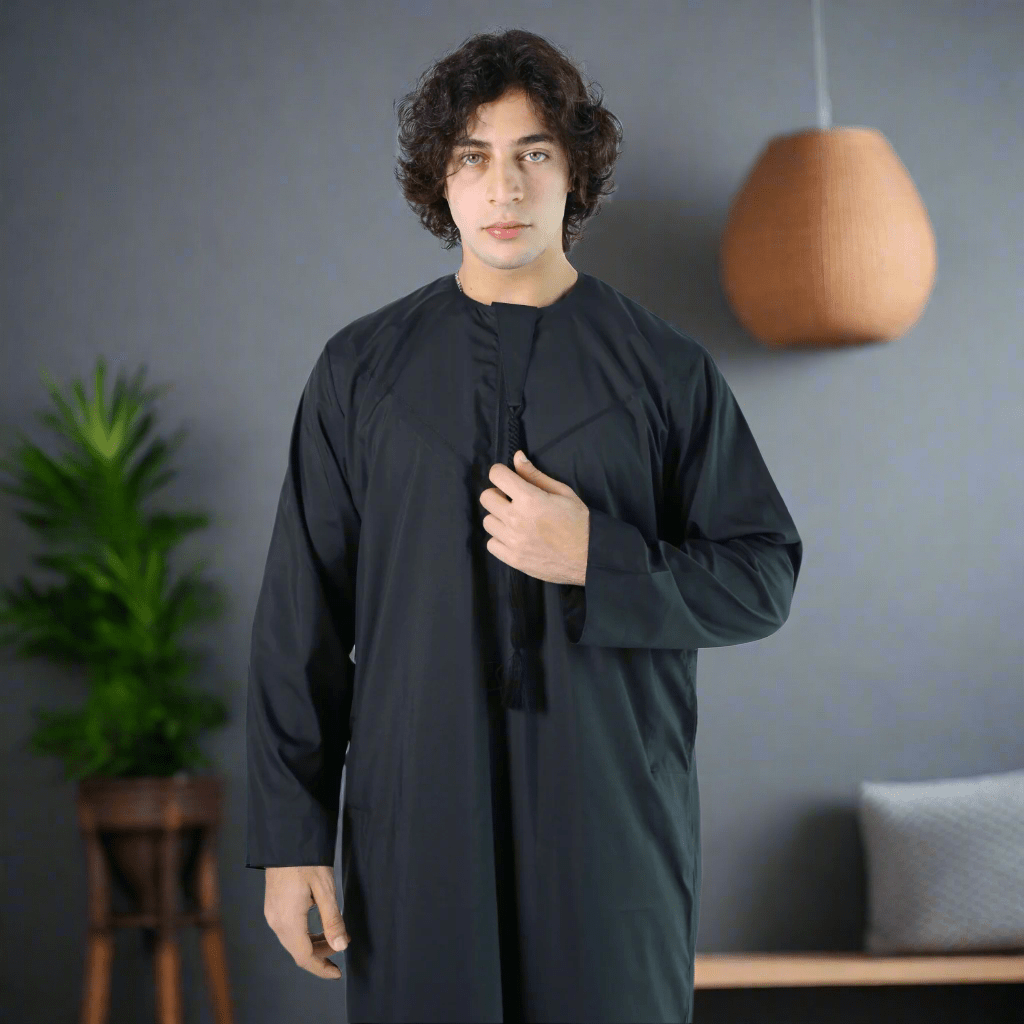 Man wearing a black long-sleeve garment against a light blue background