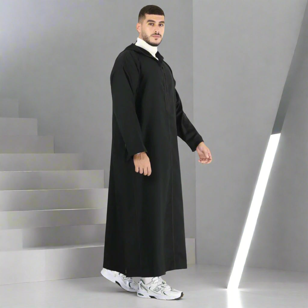 Man wearing a black abaya on a white background