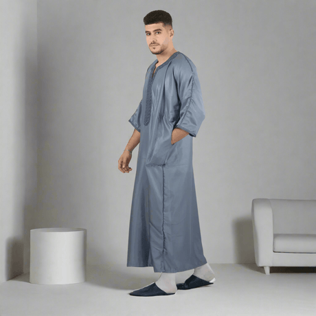 Man wearing a long gray garment on a white background
