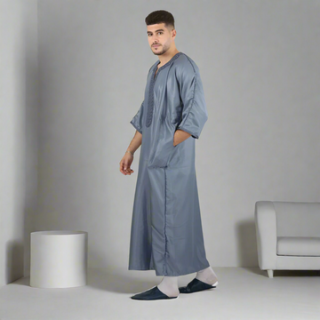 Man wearing a long gray garment on a white background