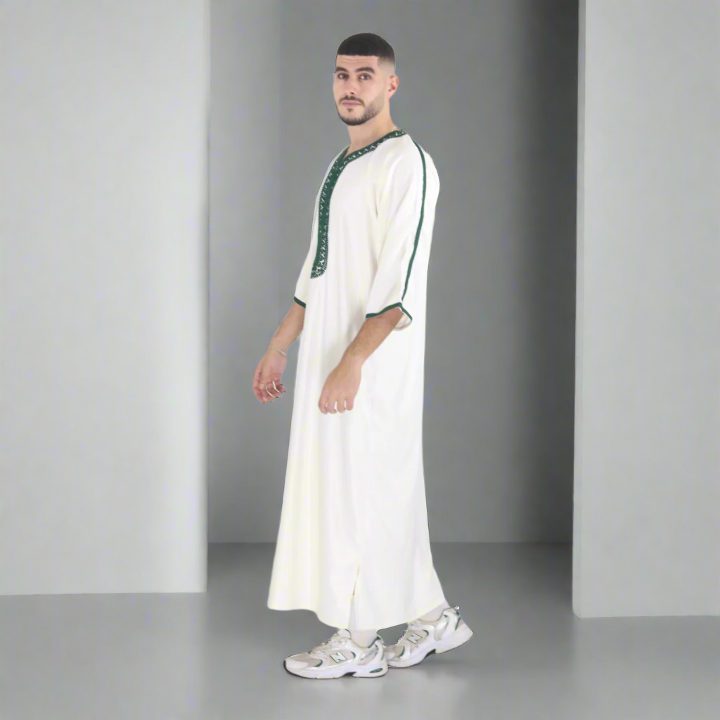 Man wearing a long white garment with green accents on a white background