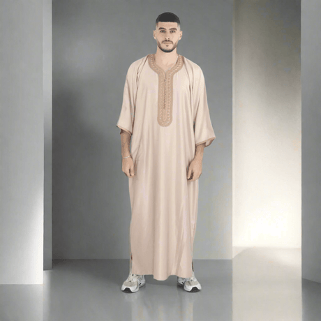 Man wearing a beige embroidered robe on a white background