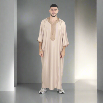 Man wearing a beige embroidered robe on a white background