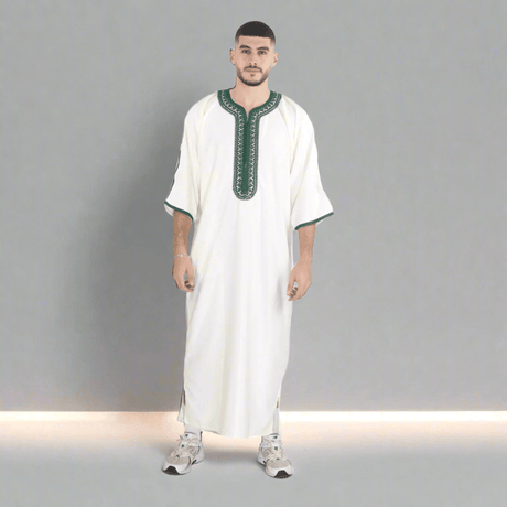 Man wearing a white traditional outfit with green accents on a white background
