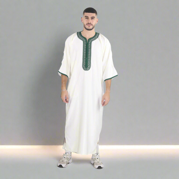 Man wearing a white traditional outfit with green accents on a white background