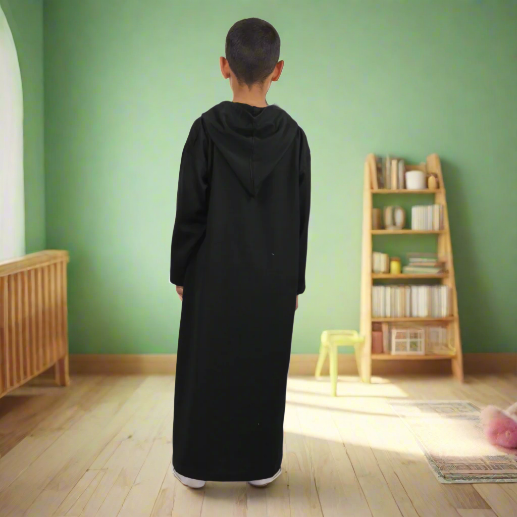 Person wearing a black abaya standing against a white background